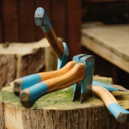 Four axes with wooden handles on a tree stump