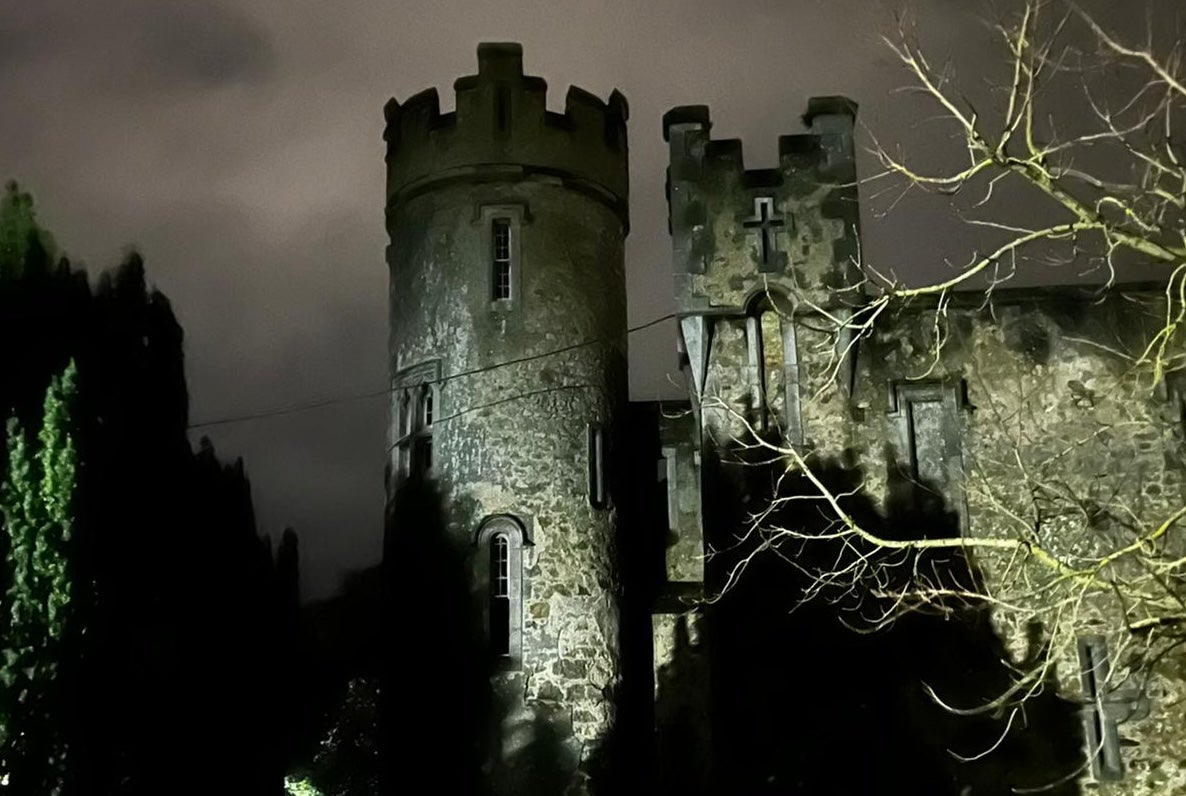 A large round castle turret lit up at night