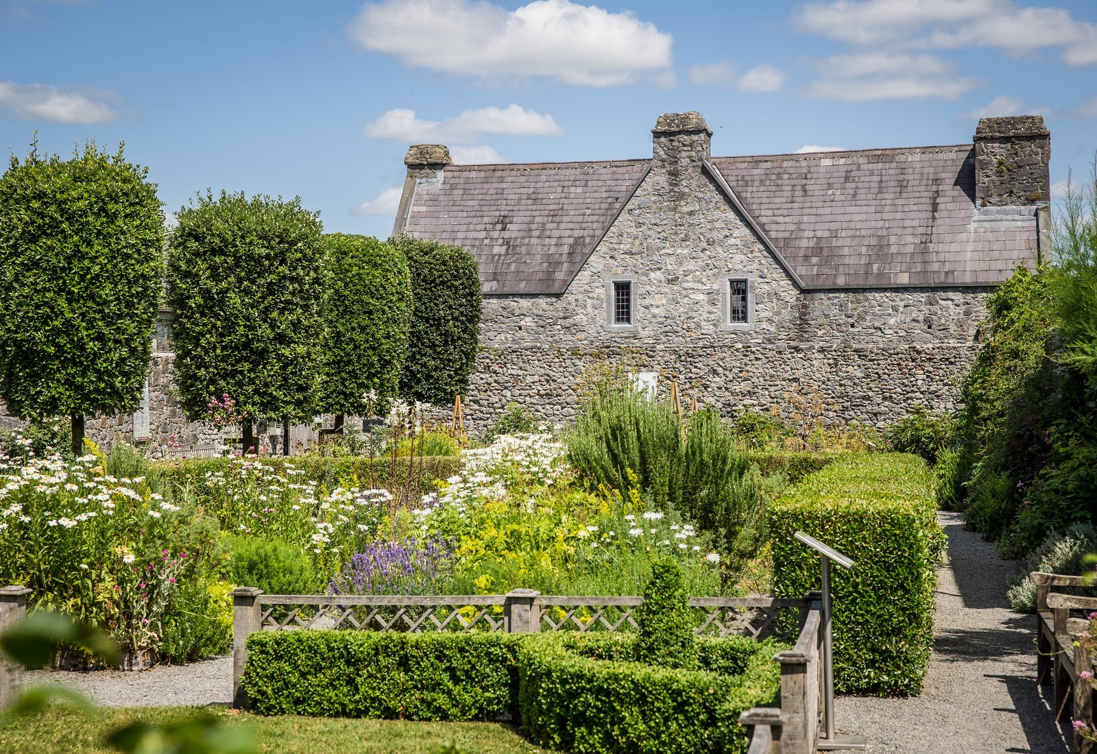 Exterior of a large stone bricked house overlooking a garden