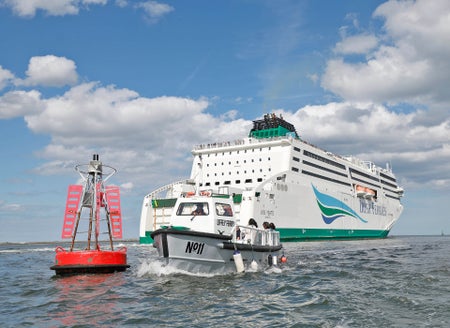 The Old Liffey Ferry number eleven near a large cruise ship
