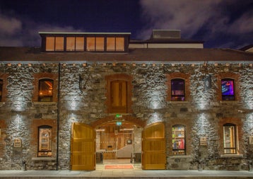 The exterior of a large building with old brick walls and large open doors