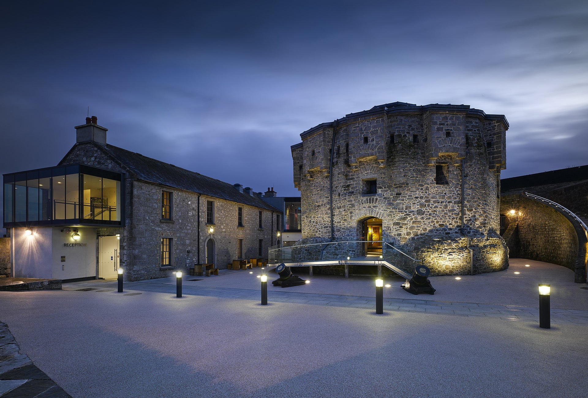 Castle at night time with pillar lights along the footpath in front