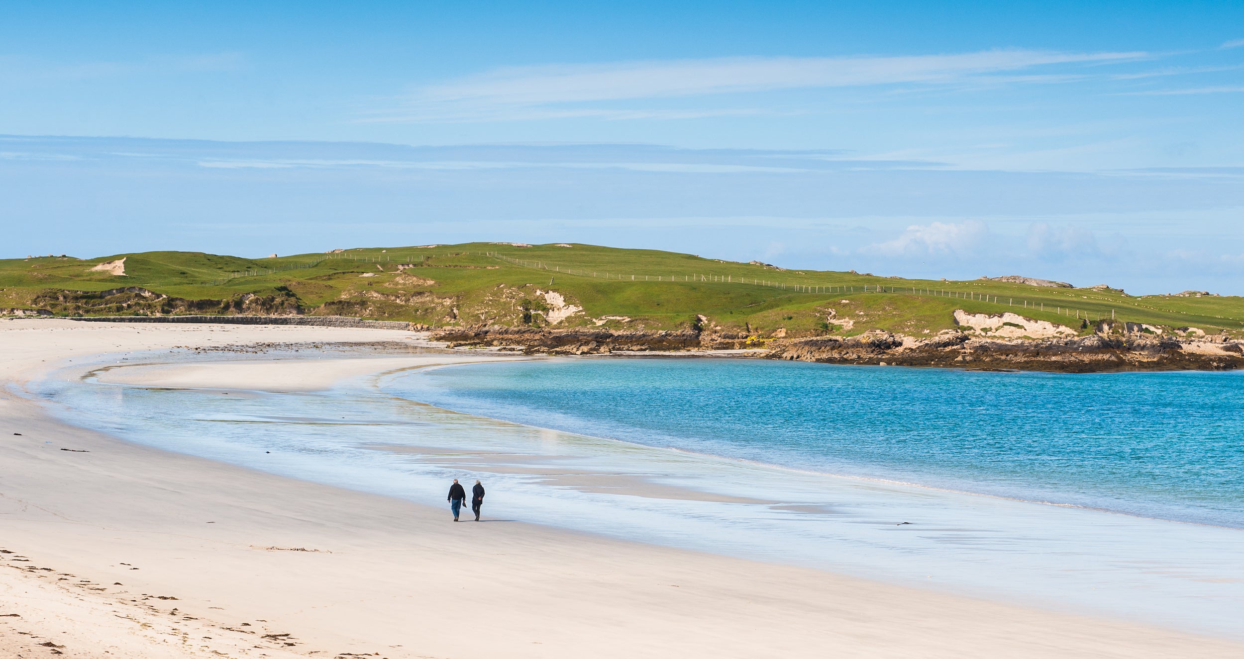 People walking on Dog's Bay Beach in Co Galway