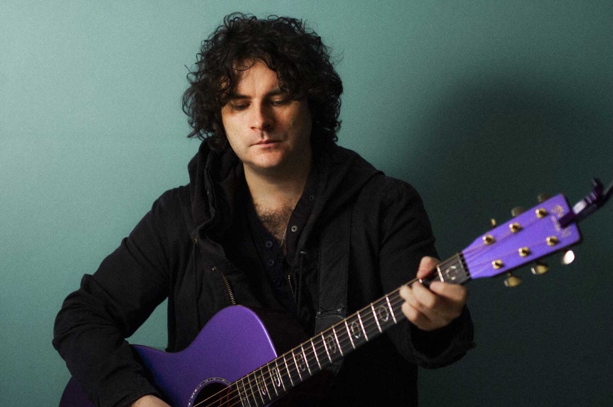 NCH Landmarks: Paddy Casey, a man looking down at purple coloured guitar he is holding