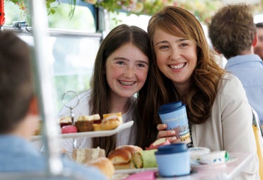 Passengers enjoying afternoon tea aboard a Vintage Tea Trips bus