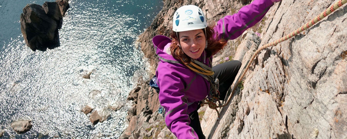 Girl climbing rockface at Donegal Climbing Muff Malin Head County Donegal