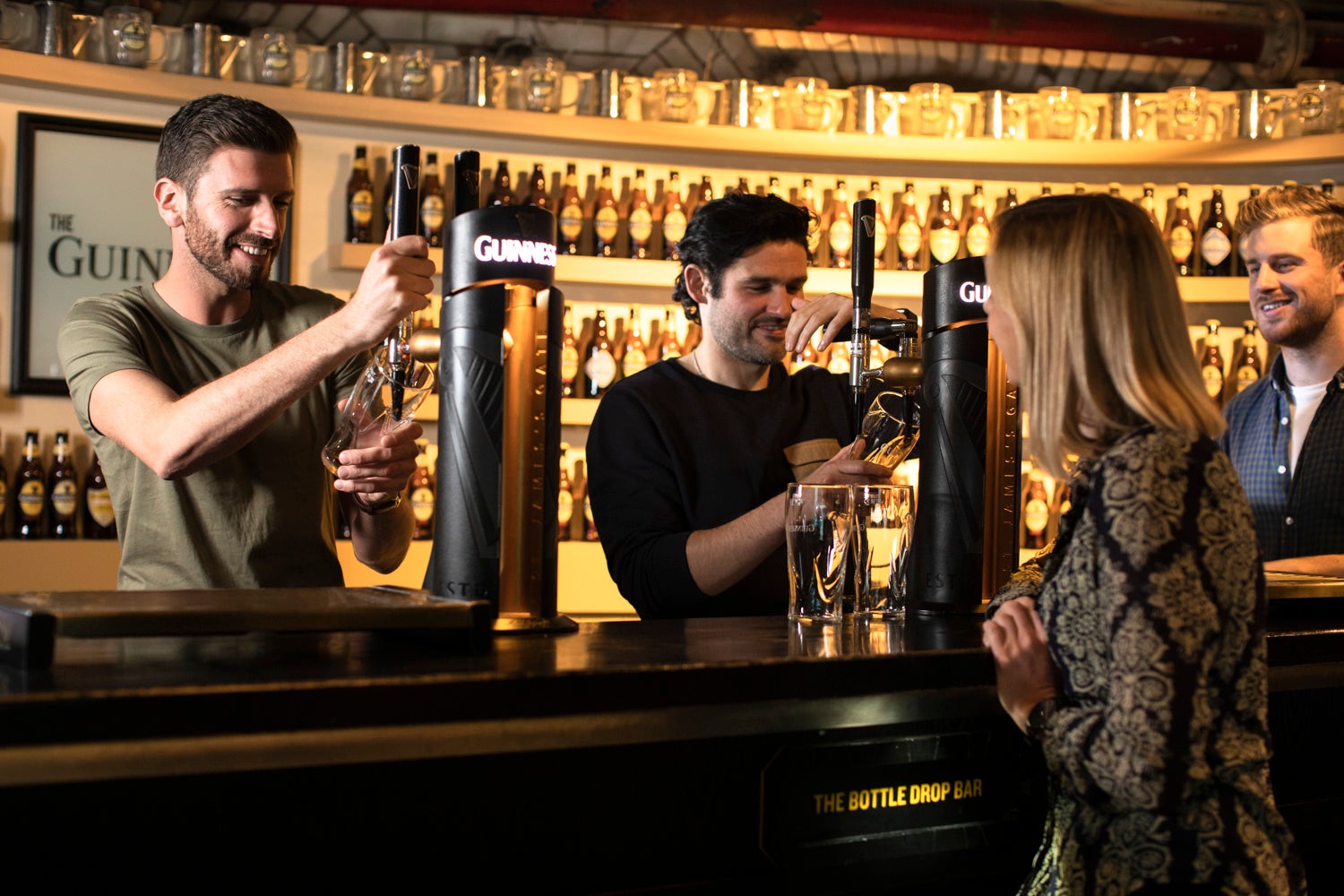 People pulling a pint at the Guinness Storehouse in Dublin city