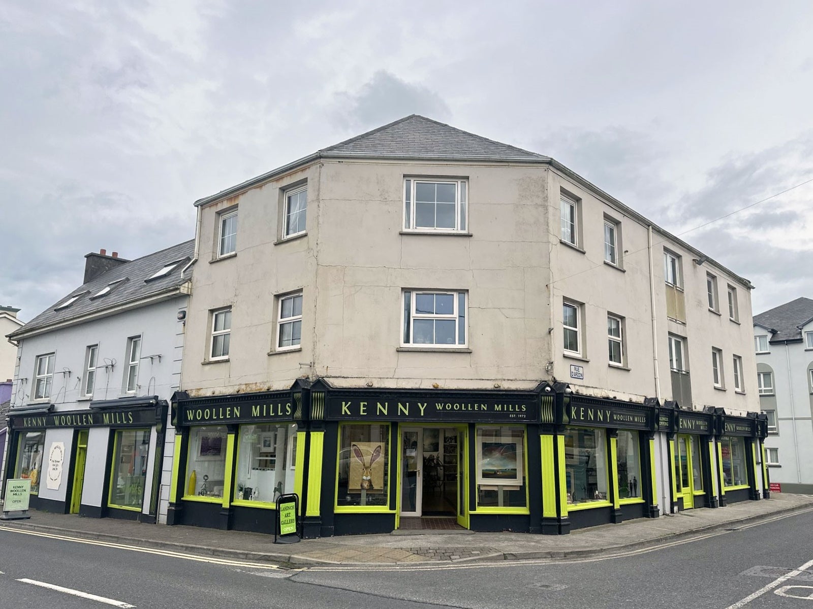 Black and yellow painted shop front with and windows and an open door