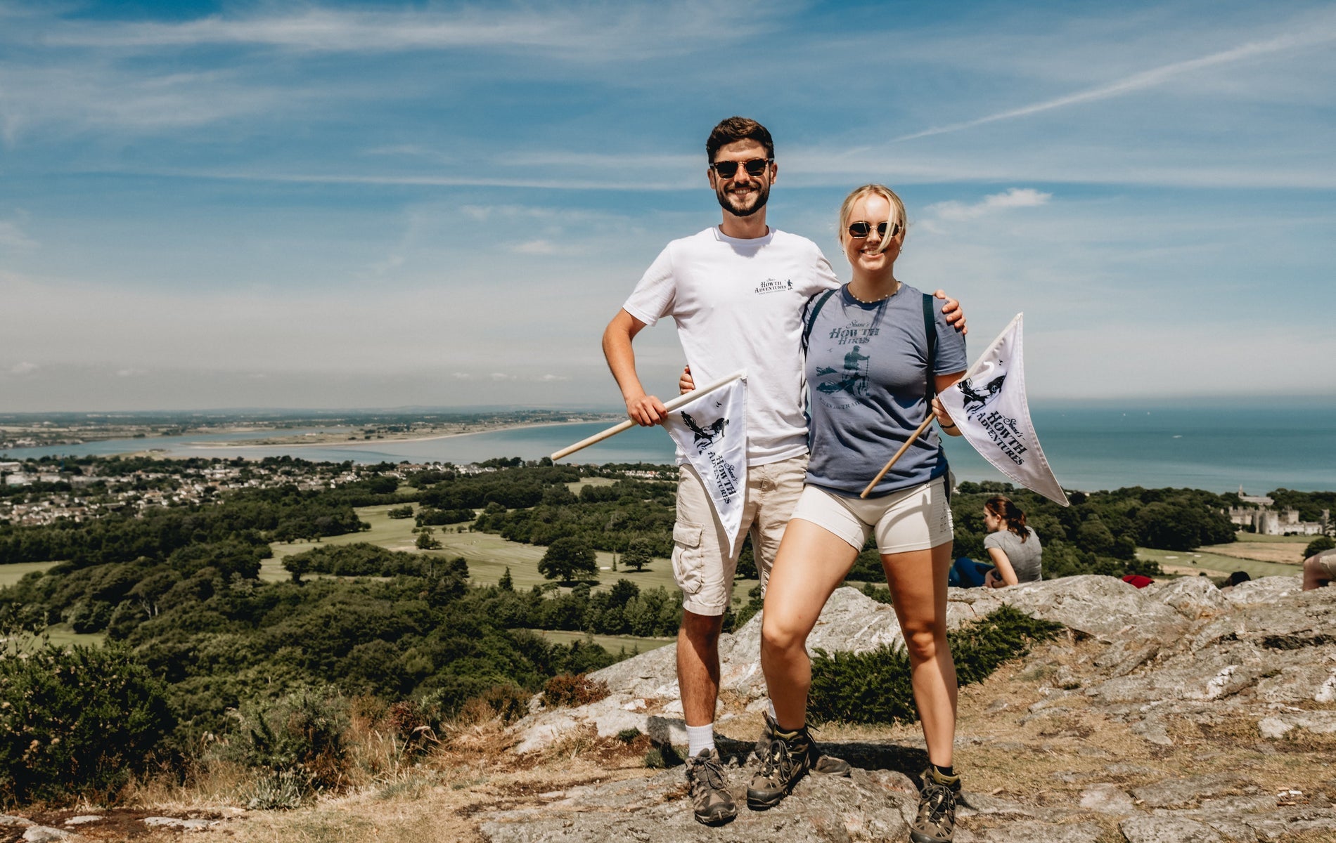 Two people standing on the top of a hill on a sunny day