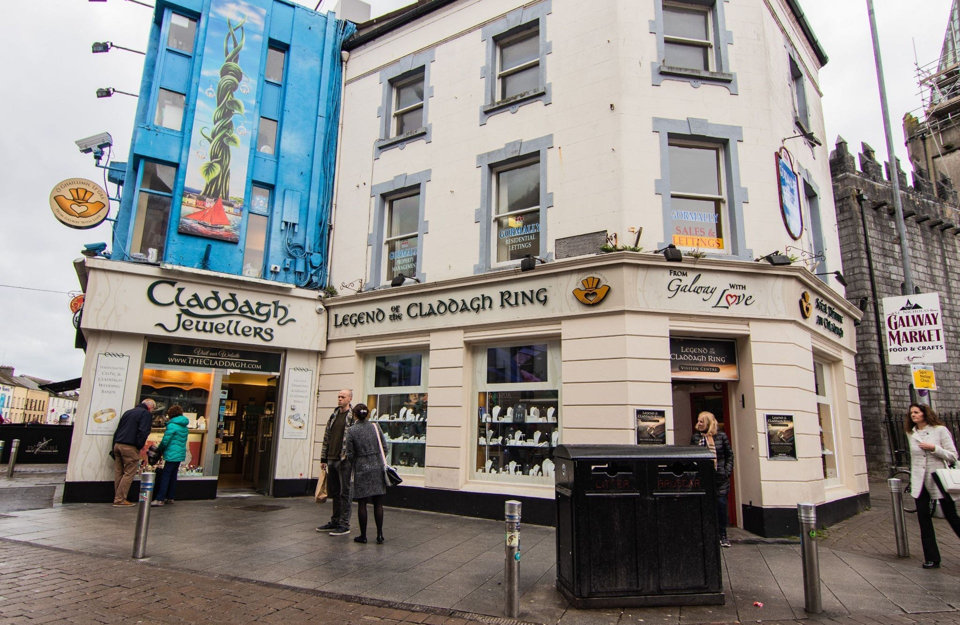 A cream coloured three storey building and shopfront of Claddagh Jewellers on a busy street