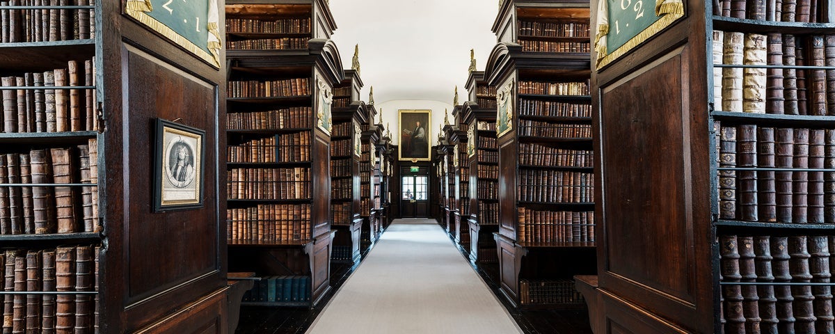 A room with rows of books each side of a walkway