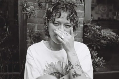 Black and white photo of person covering their nose with a hand.