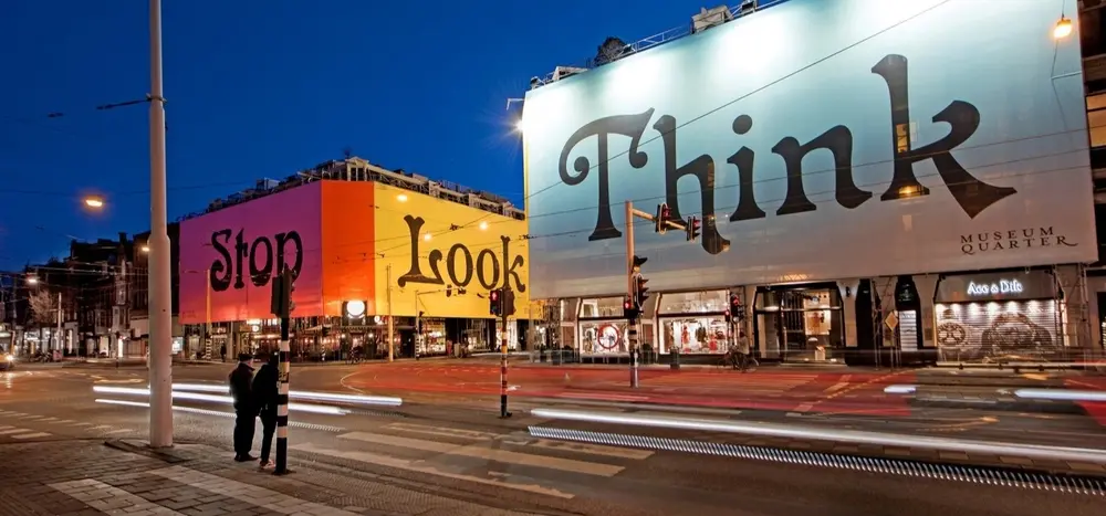 A series of buildings with coverings mentioning the words 'Stop', 'Look' and 'Think'.