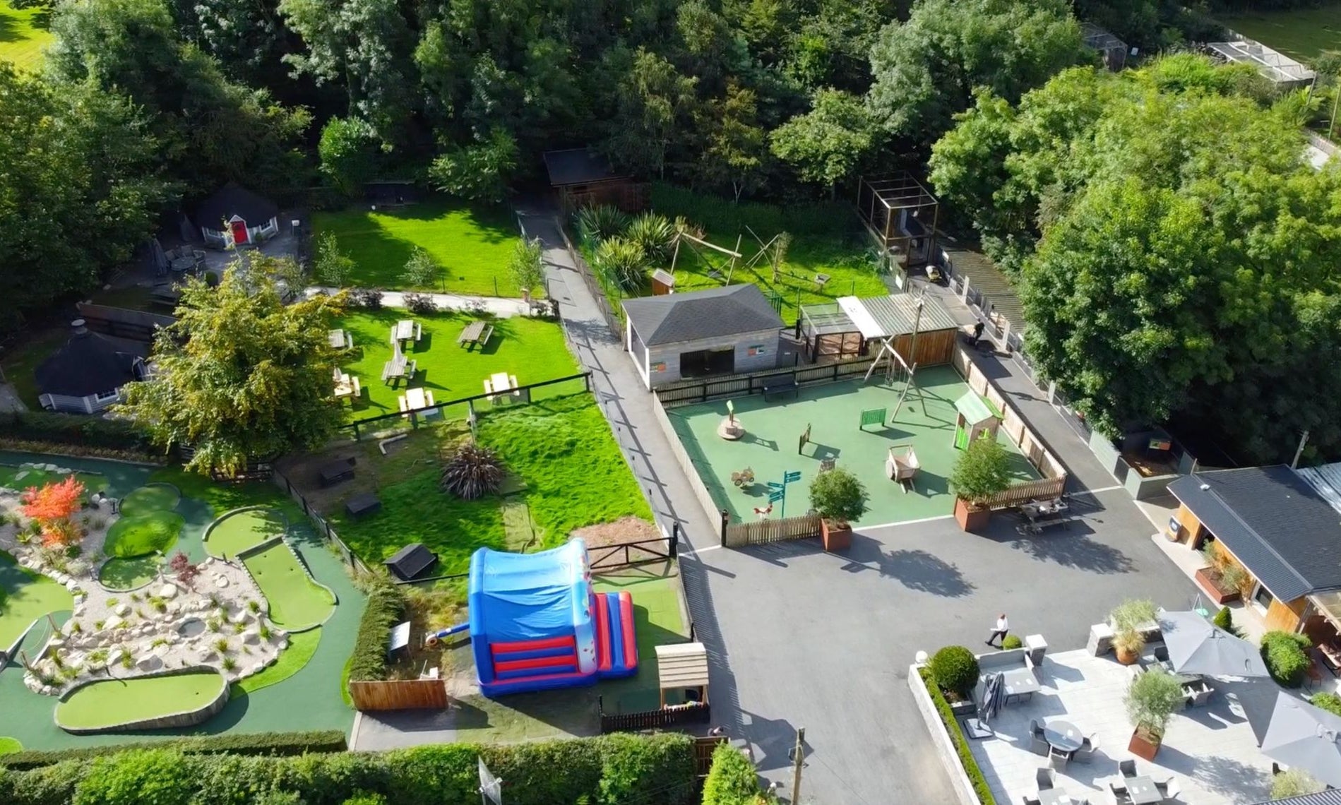 Aerial view of a farm with sheds grass wooden gates and a play area