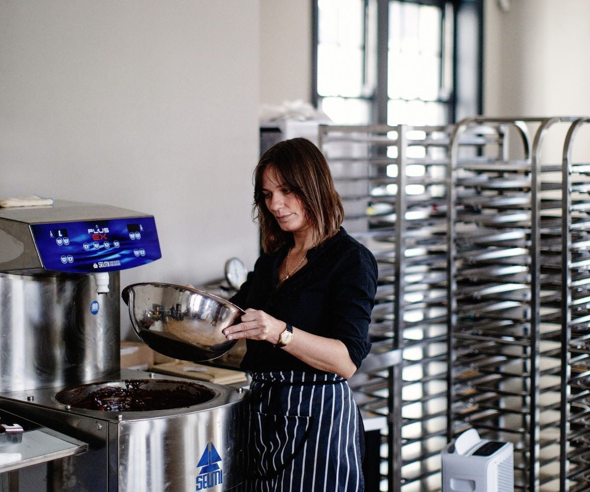 A person wearing an apron holding a mixing bowl