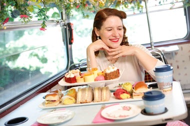 A lady sitting at a table set with an afternoon tea