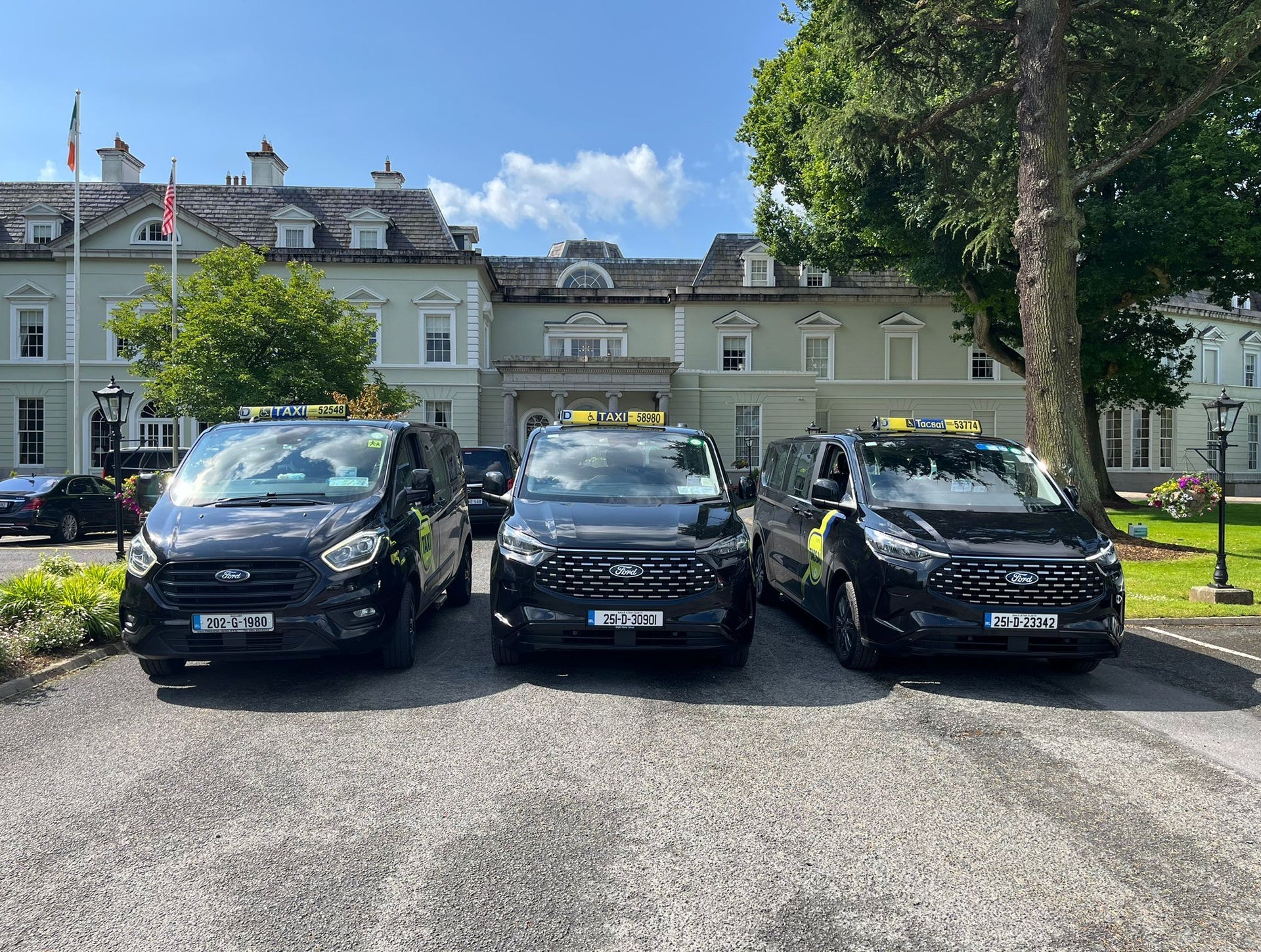 Three black coloured accessible people carrier taxis lined up in a row