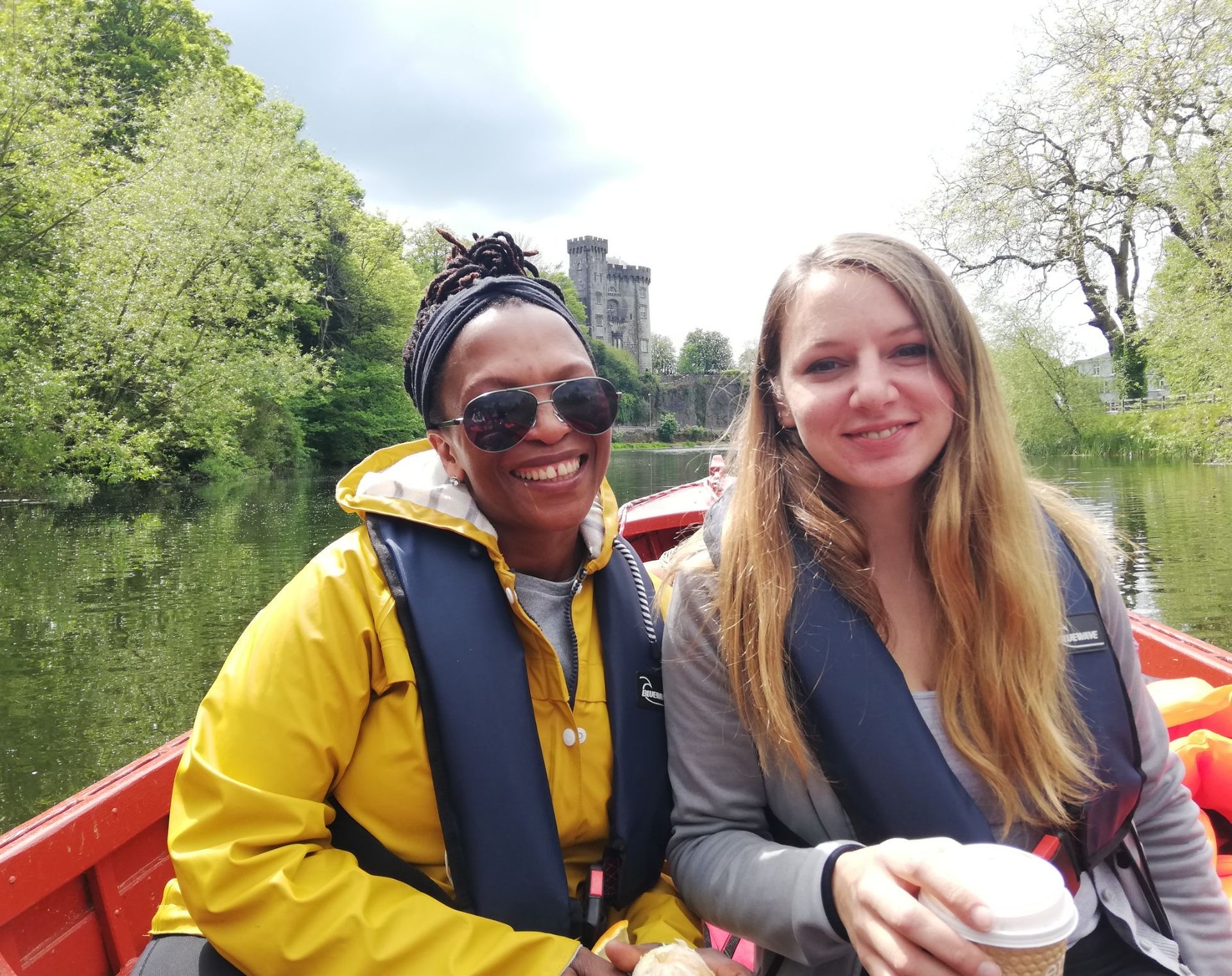 Two girls in a boat on River Nore with Kilkenny Castle in the background