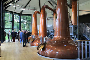 A group of people near copper stills at Royal Oak Distillery