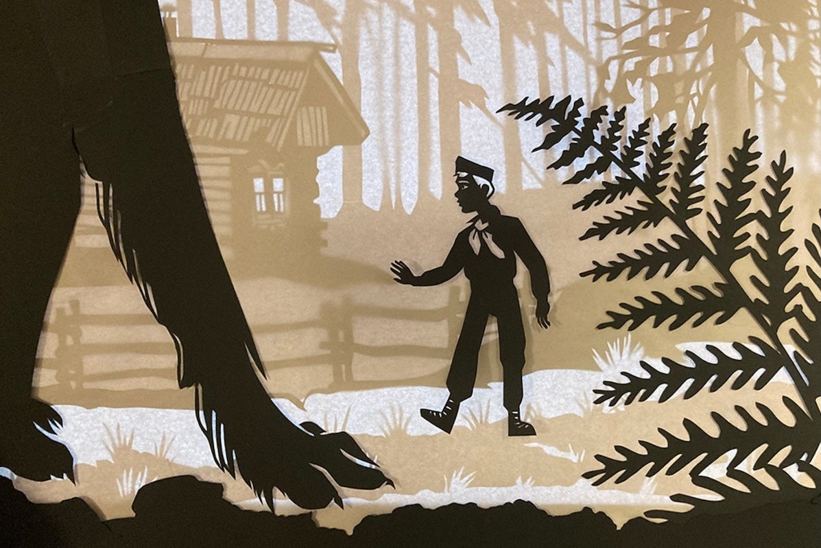 Peter and the Wolf with the NSOI, black, beige and white image of a wolf's large forelegs and a boy against a cabin and woods.