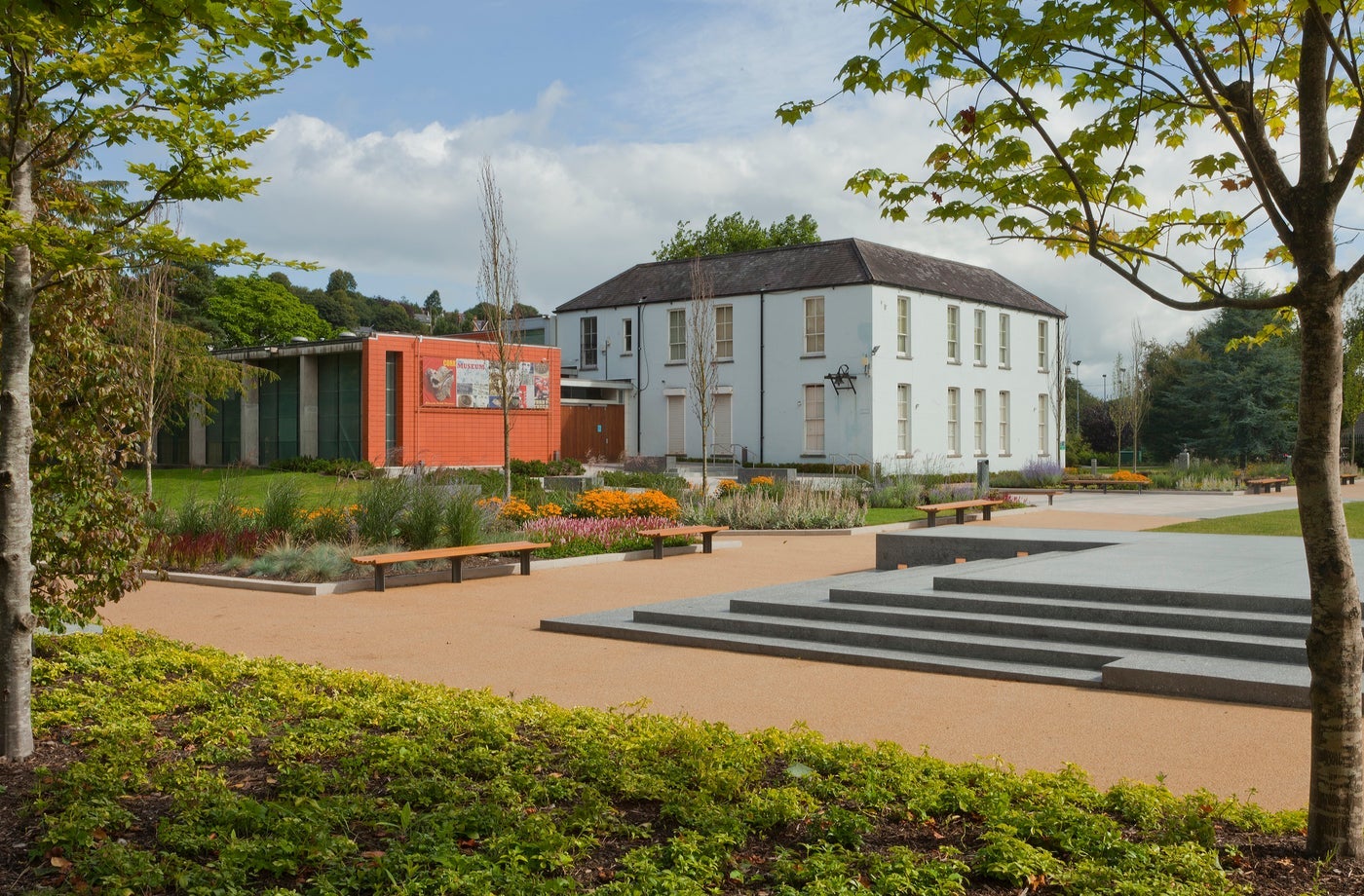 A Georgian style house set on grounds with lots of shrubs and trees