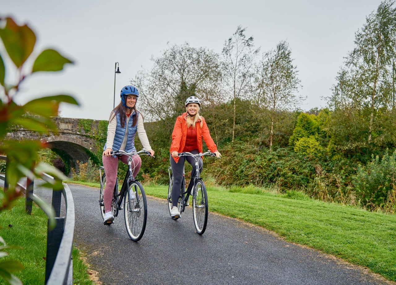 Two people cycling on a greenway