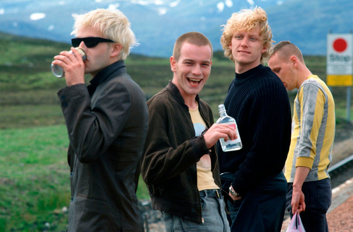 Four men drinking alcohol at the side of a road.