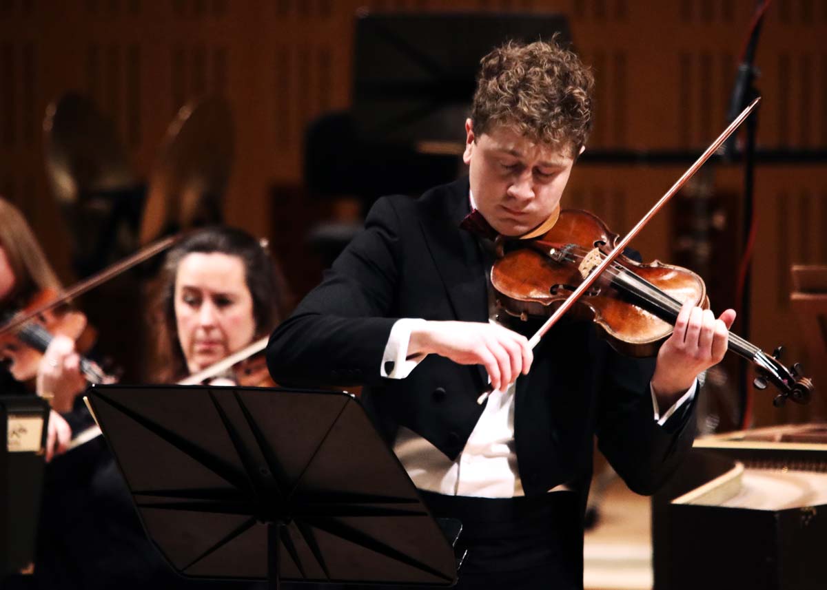 Patrick Rafter playing the violin in concert attire.