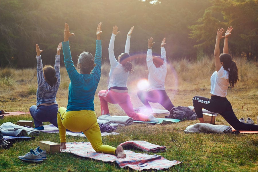 Five ladies in an outdoor setting taking part in a Pilates class