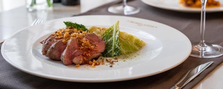 A dish from the menu of Moreland Grill with slices of meat and garnish