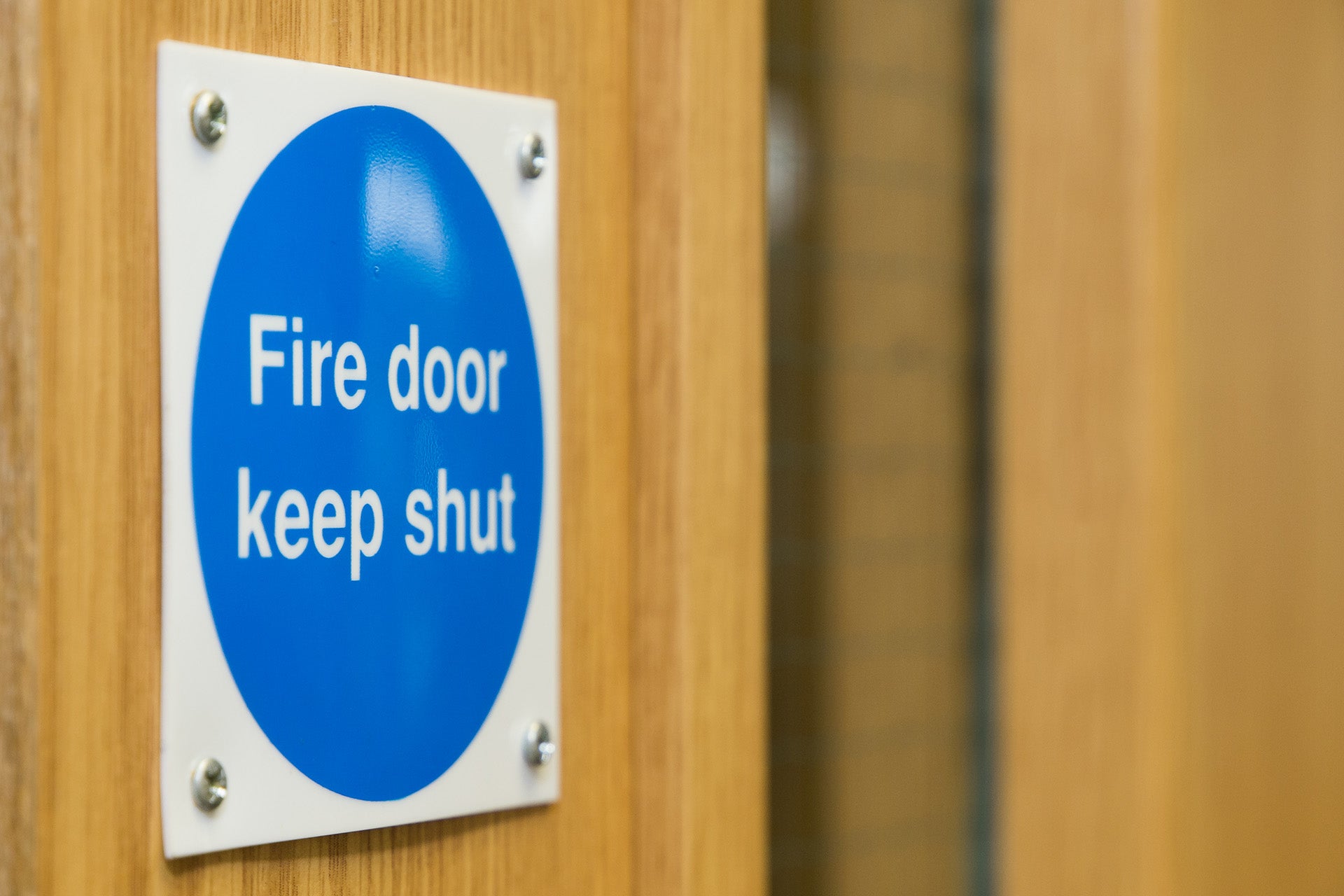 Photo of a wooden door with a 'Fire door keep shut' sign