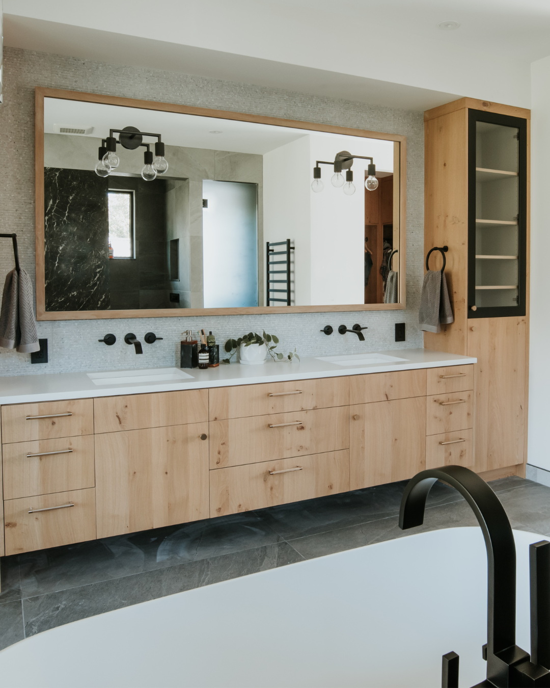 A bathroom with a large mirror and a tub - wood veneer - natural oak