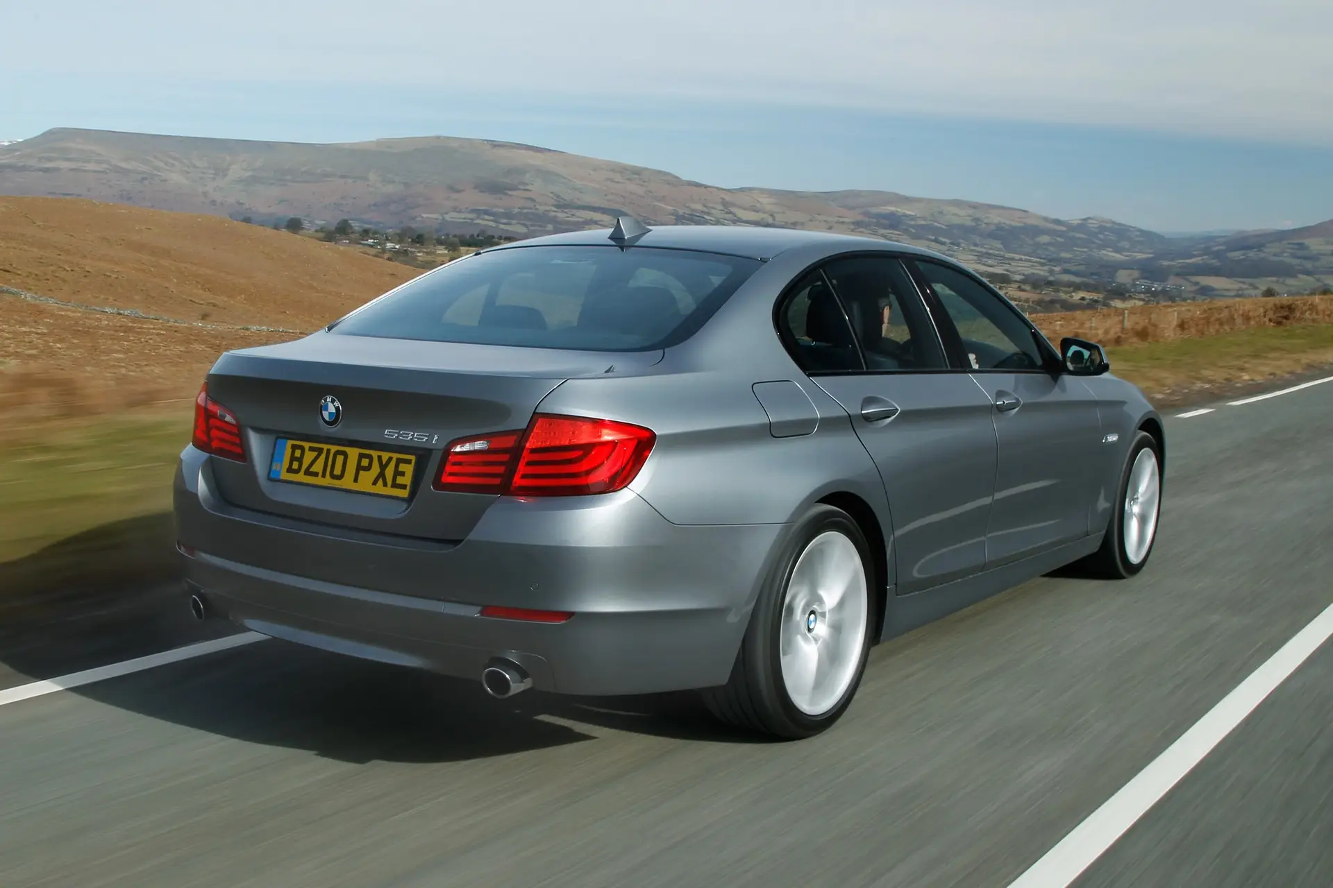 BMW 5 Series (2010-2017) Review: Exterior rear three quarter photo of the BMW 5 Series on the road