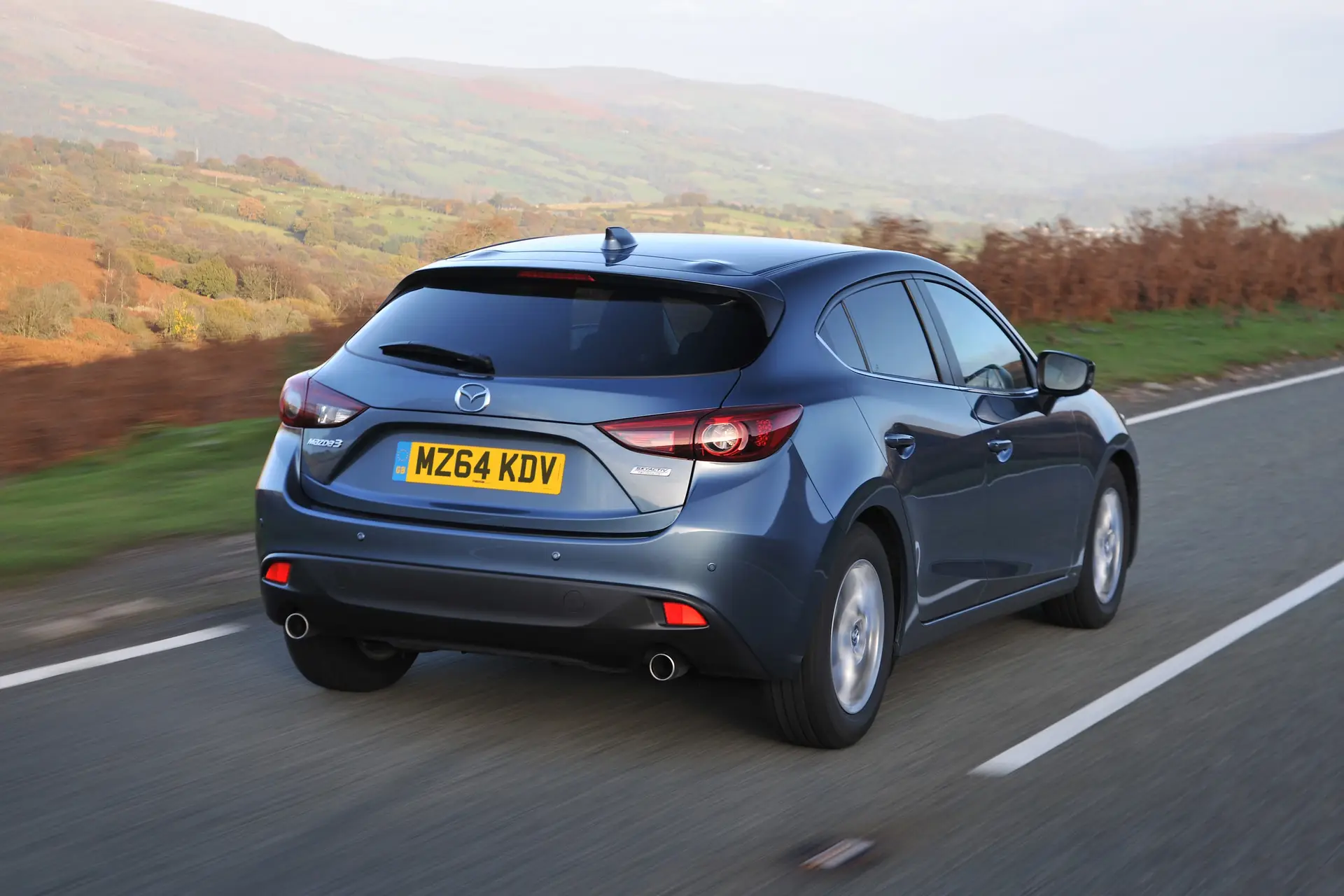 Mazda 3 (2014-2019) Review: exterior rear three quarter photo of the Mazda 3 on the road