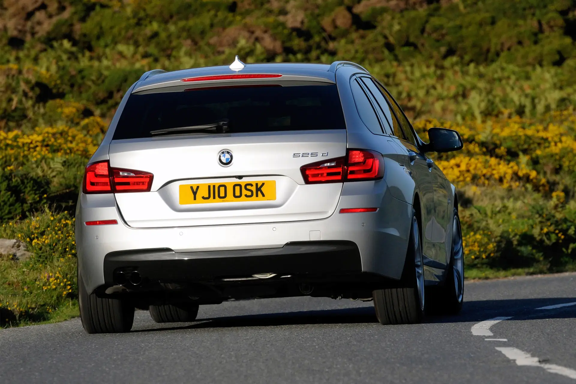 BMW 5 Series Touring (2010-2017) Review: Exterior rear photo of the BMW 5 Series Touring on the road