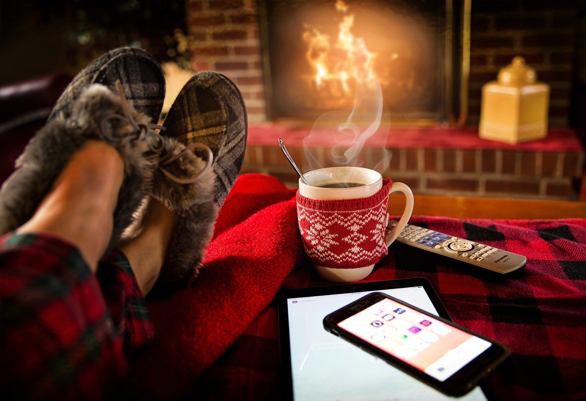 Een huiselijk plaatje, blote voeten in pantoffels, warme chocolademelk en een open haard vuur. Kerstsfeer.