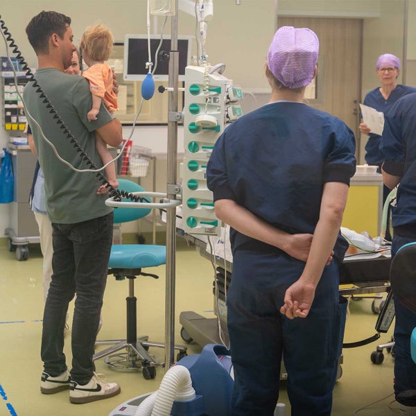 Ouders dragen hun kind naar de OK en hebben geen blauw pak aan