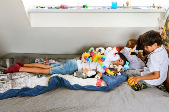 Two children in a bed with stuffed animals for a sleep study