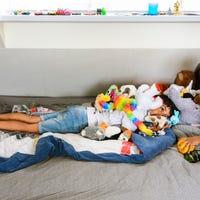 Two children in a bed with stuffed animals for a sleep study