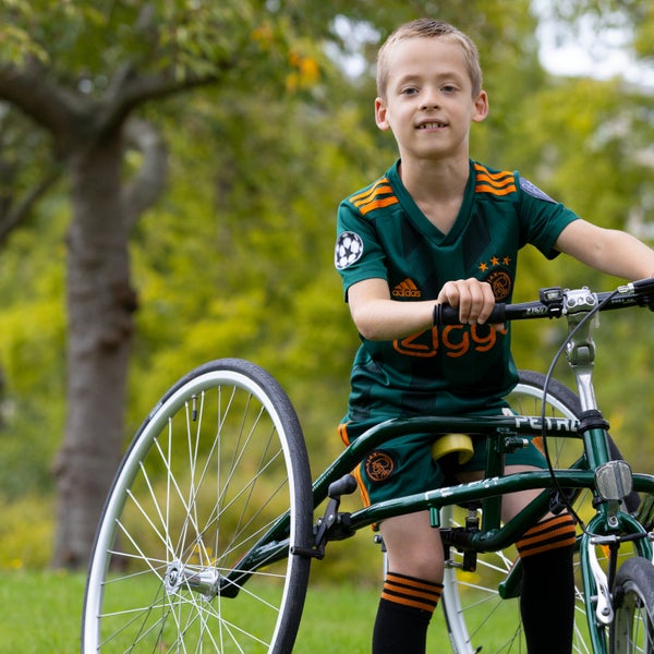 Jongen met cerebrale parese zit op een fiets