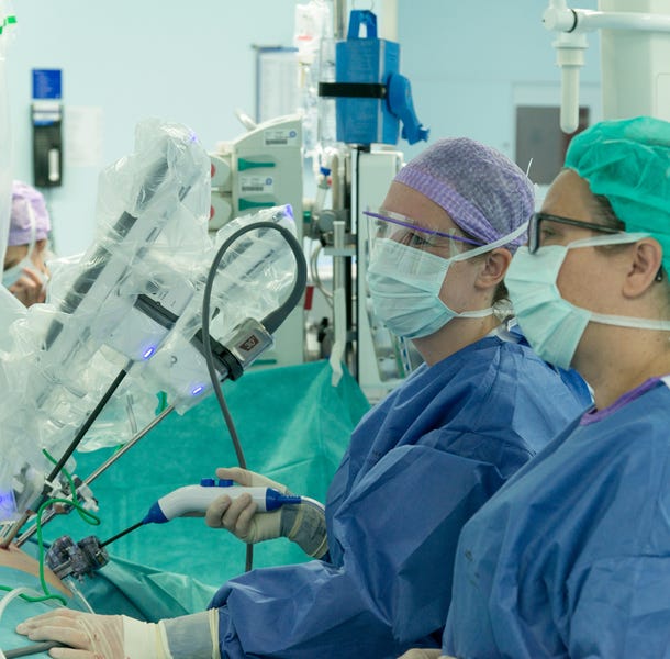 Twee chirurgen besturen een operatierobot.
