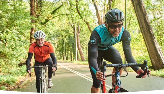 Twee mannen op racefietsen in het bos.