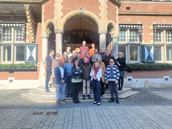 Mensen van de projectgroep RAPHAEL, dat onderzoek doet naar palliatieve zorg bij hartfalen, poseren voor een oud gebouw.