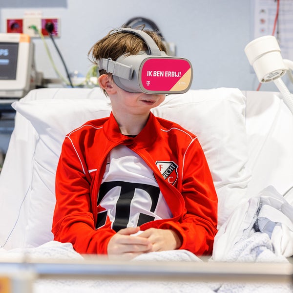 Thomas in een ziekenhuisbed met FC Utrecht kleding en VR-bril