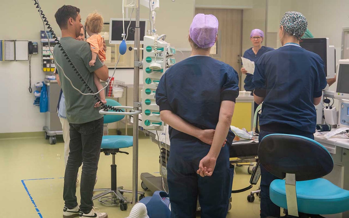 Ouders dragen hun kind naar de OK en hebben geen blauw pak aan