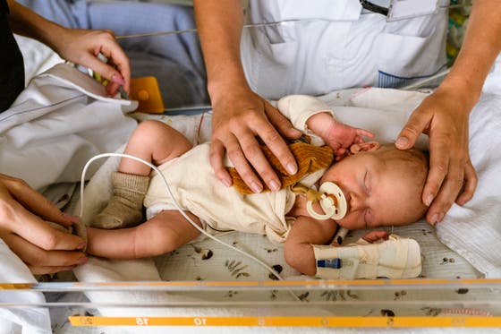 Een kleine baby in een ziekenhuisbedje. 