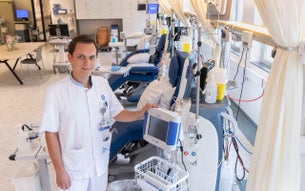 Mark Jordaans op de dialyseafdeling naast een dialyseapparaat.