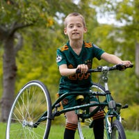 Jongen met cerebrale parese zit op een fiets