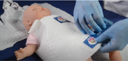 Een babypop draagt een wrap die wordt gebruikt voor koelingstherapie