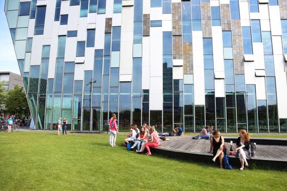 Gebouw van de geneeskunde opleiding, op voorgrond zitten studenten op terras